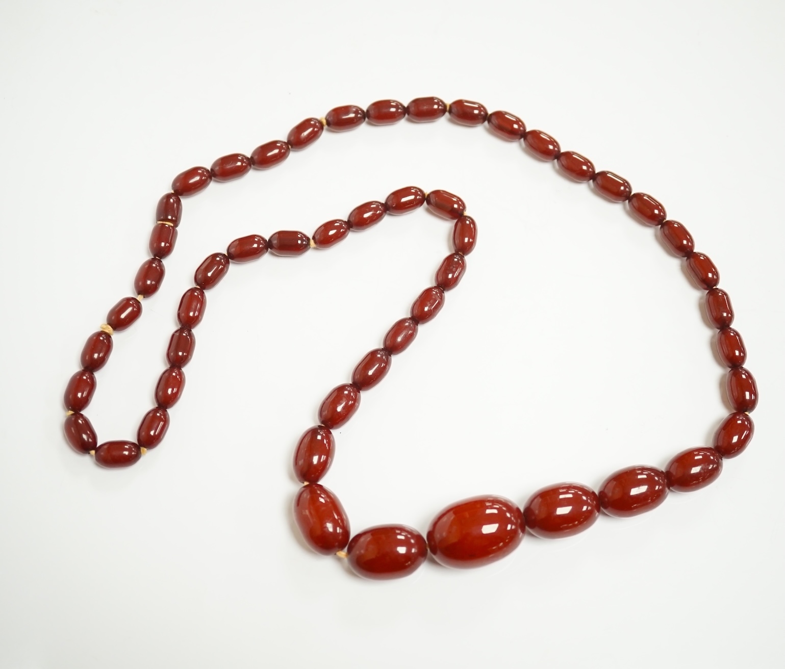 A single strand graduated simulated cherry amber oval bead necklace, 70cm, gross weight 51 grams. Condition - fair to good